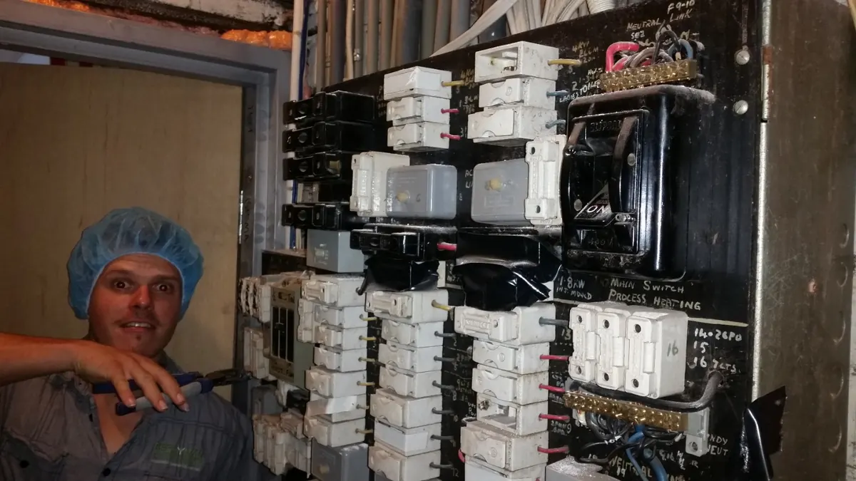 Electrical work being carried out at an older switchboard