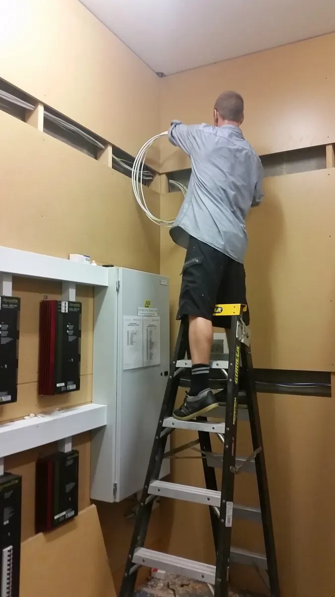 Electrician at residential switchboard from genuine electrical work archive